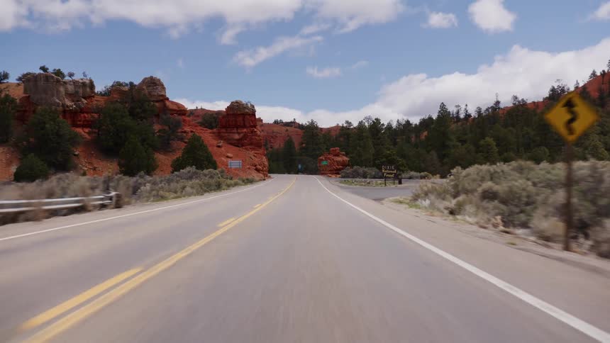 A scenic point-of-view drive along a highway winding through the majestic red rock formations of Red Canyon, Utah