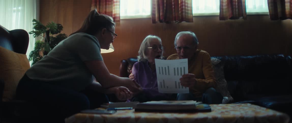 A financial advisor shares a positive financial report with an elderly couple, and they react with joy and relief, shaking hands to celebrate