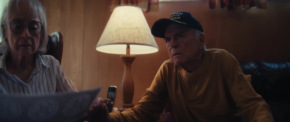 A caring doctor explains the results of a brain scan to a concerned elderly couple during a home visit