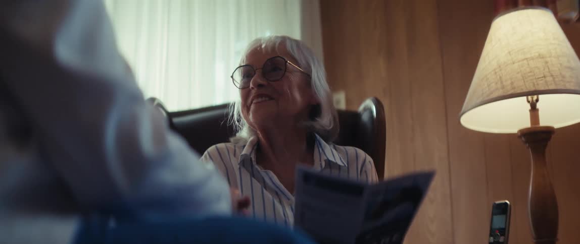 A friendly healthcare professional shakes hands with an elderly veteran while his wife smiles and listens to the care options available