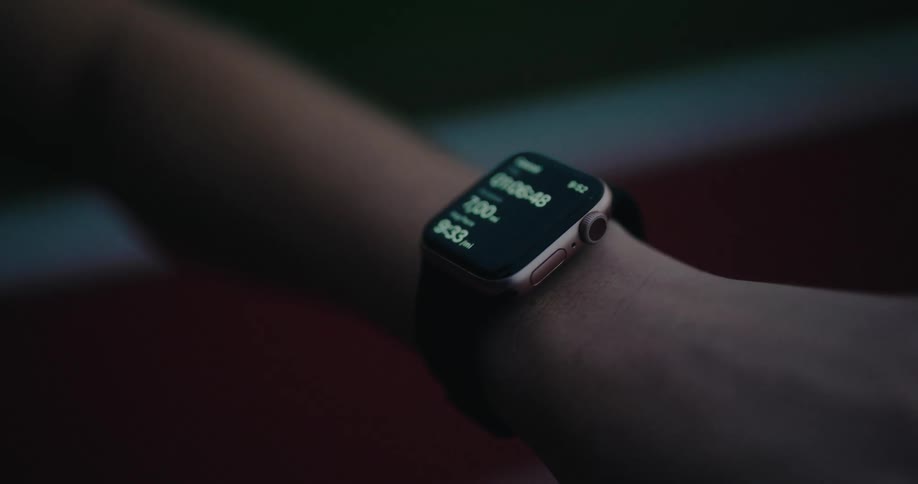 Close up of a smartwatch on a runner's wrist displaying the results of a 7-mile run at night