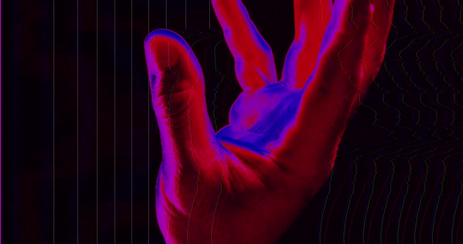 A human hand slowly opens from a fist with a vibrant red and blue digital glitch effect against a dark background
