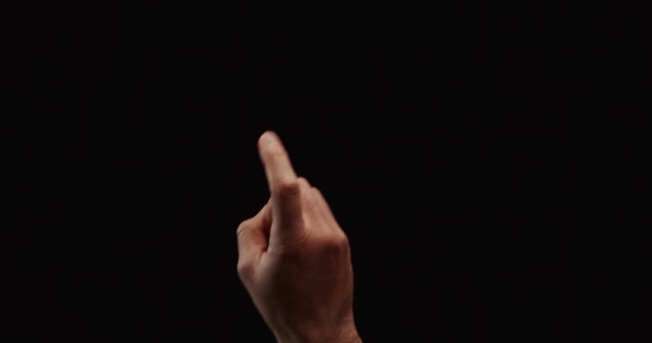 A man's hand wags his index finger in a gesture of disapproval against a black background