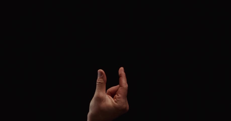 A man's hand gestures small, big, and rock and roll in slow motion against a dark isolated background