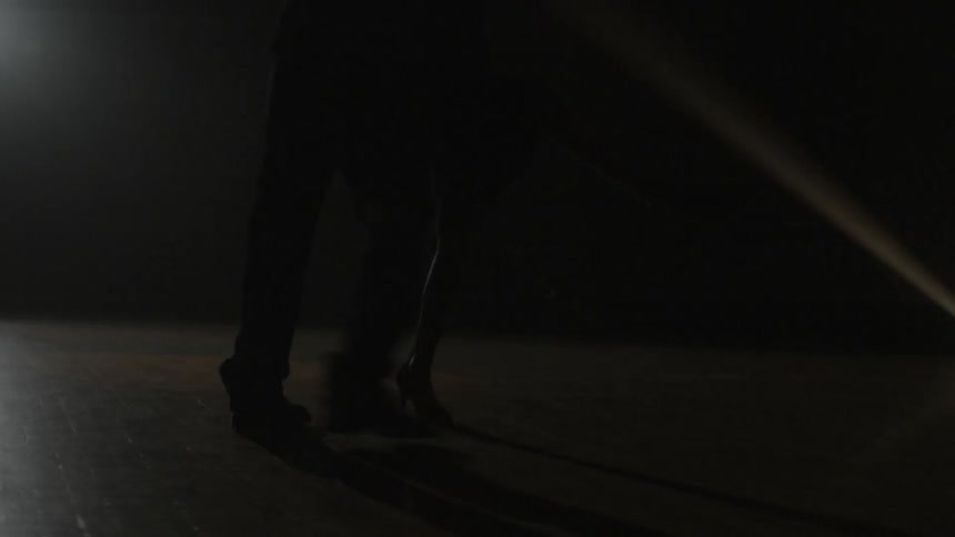 Spotlights shine on the floor as a couple dances