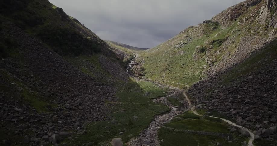 Moving clouds cast a shadow on a mountain valley