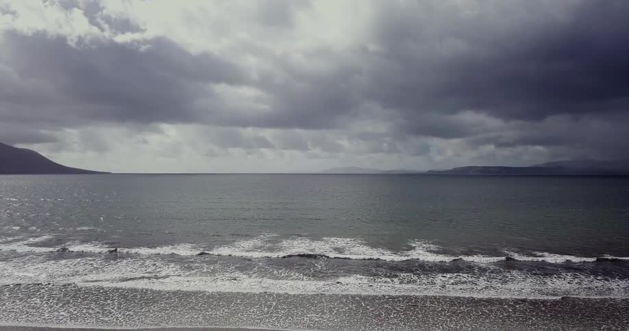Waves wash ashore on a cloudy day