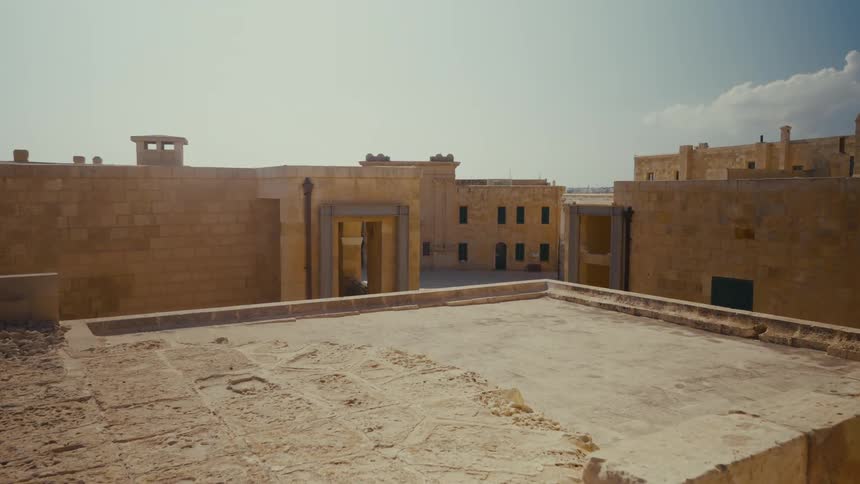A slow dolly shot reveals the weathered stone architecture of a historic Mediterranean fortress