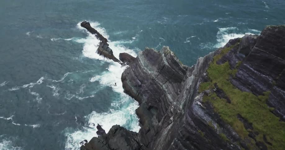 Ocean waves crash into a rocky cliff