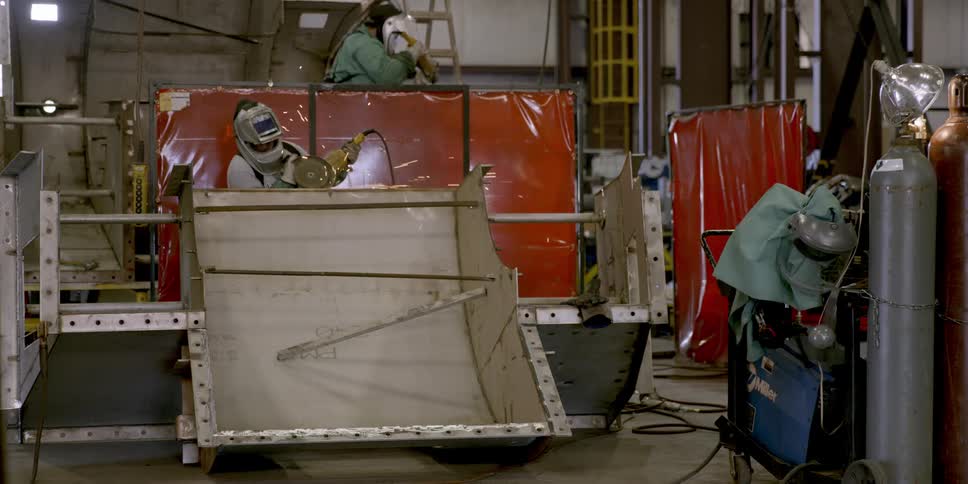 Factory workers use power tools