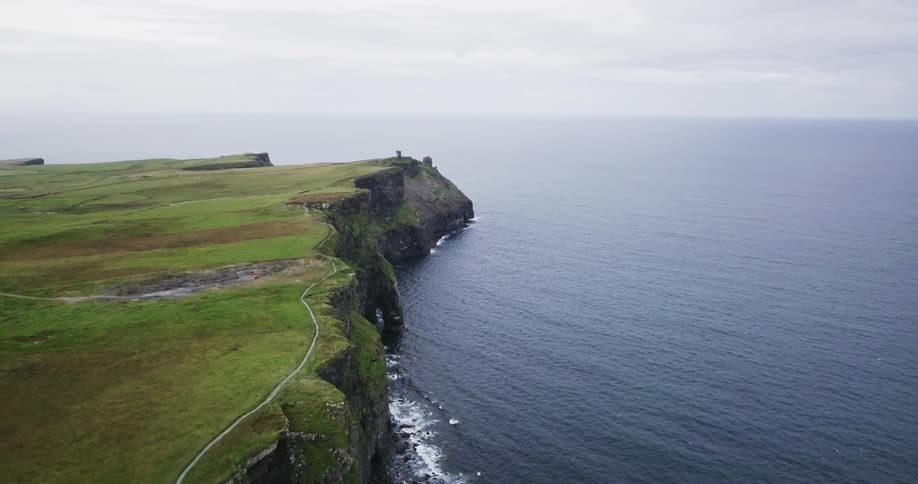 A lush green bluff juts out into the ocean
