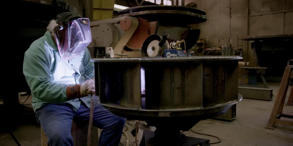 A man is working with a torch in a shop