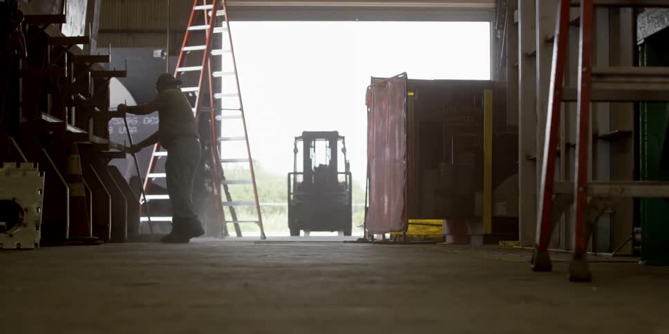 A worker sweeps a warehouse floor