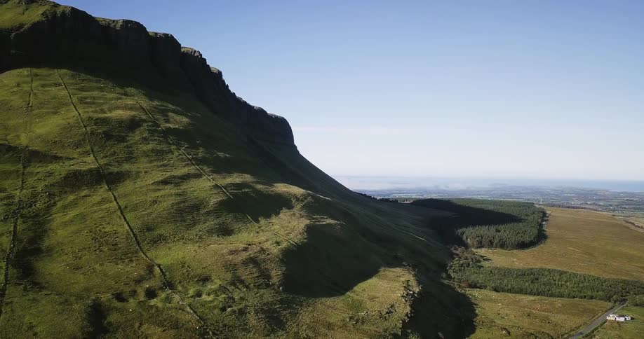 A tall mountain has green all over