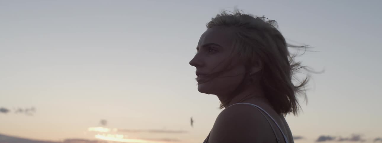 A woman is standing in the heavy wind at dawn