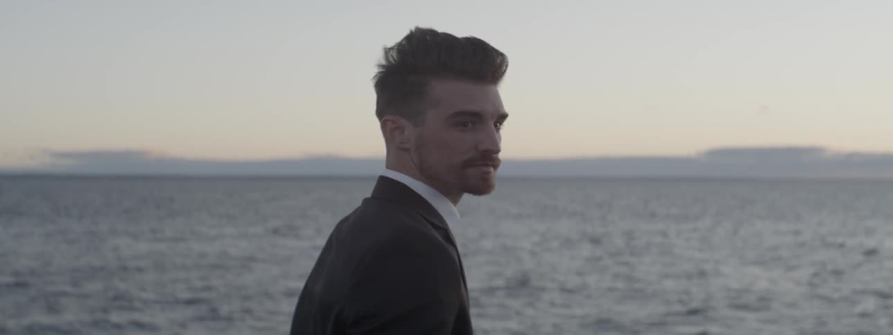 A man turns around on a pier