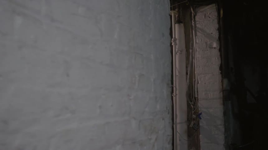A man walks through a building while wearing a heavy coat