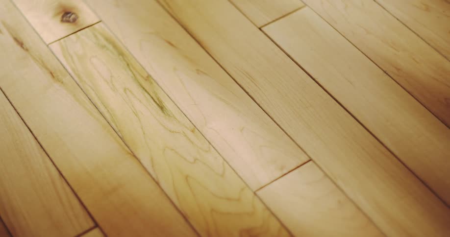 A close-up time-lapse captures a beam of sunlight moving across a beautiful hardwood floor, highlighting the wood grain
