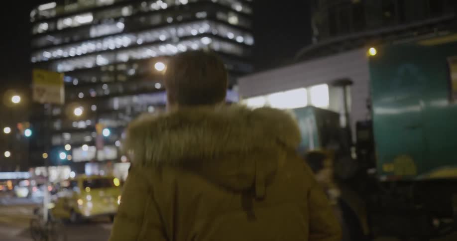 A man walks past crowds in a city