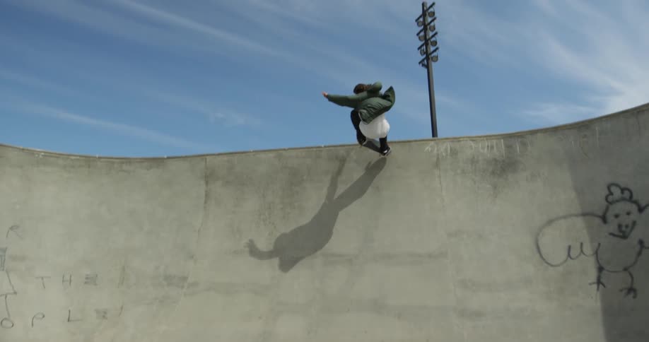 A skateboarder does a jump on a ramp