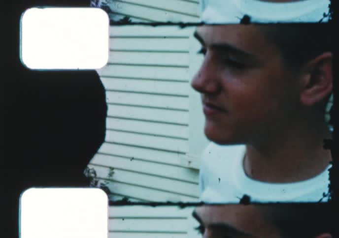 An experimental stop-motion animation created from a distressed and damaged vintage film strip shows a smiling young boy
