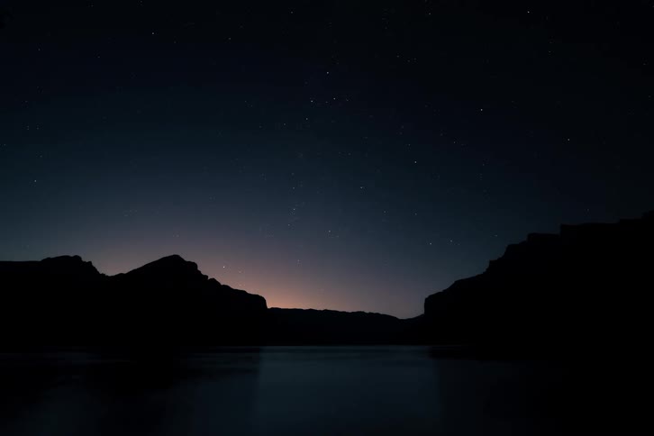 A stunning time-lapse shows the Northern Lights fading into a starry night sky, reflecting over a calm mountain lake