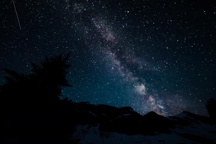 A breathtaking night-to-day timelapse captures the Milky Way and countless stars moving across the sky, eventually giving way to the dawn over a snowy mountain landscape