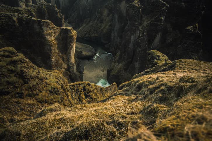 A timelapse of sunlight and shadows moving across a deep, majestic canyon with a river flowing at the bottom