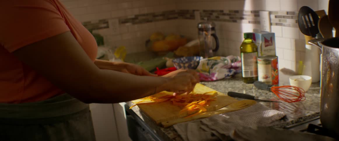 A woman peels carrots in a kitchen