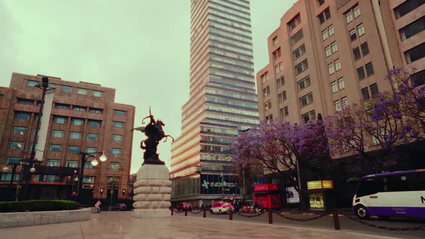 Iconic Torre Latinoamericana skyscraper revealed in a slow downward tilt over a city square in Mexico City
