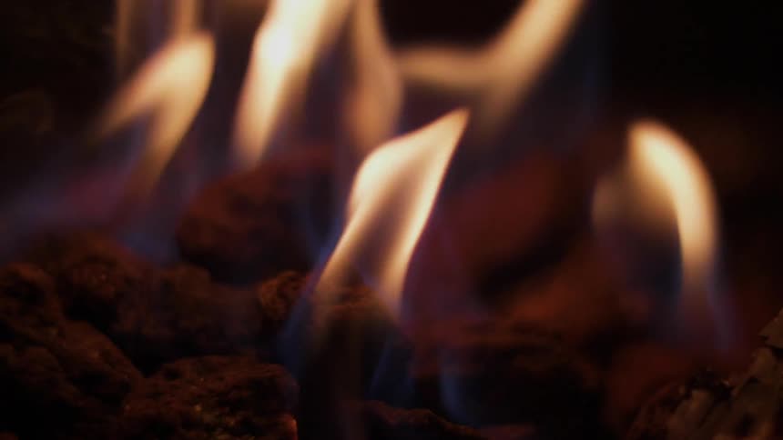 A fire slowly burns wood to ash