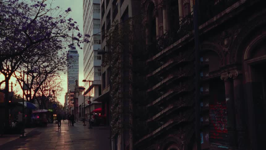 Sunrise over a quiet Mexico City street with historic buildings and the iconic Torre Latinoamericana skyscraper in the background