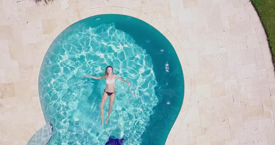 A woman in a bikini swims in a small pool