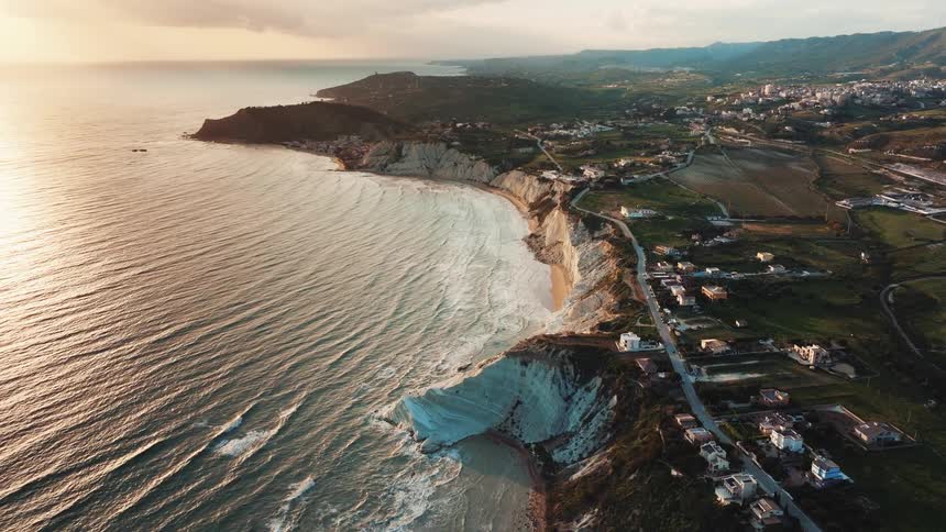 Epic aerial view of the stunning white cliffs of Scala dei Turchi along the Sicilian coast during a golden sunset