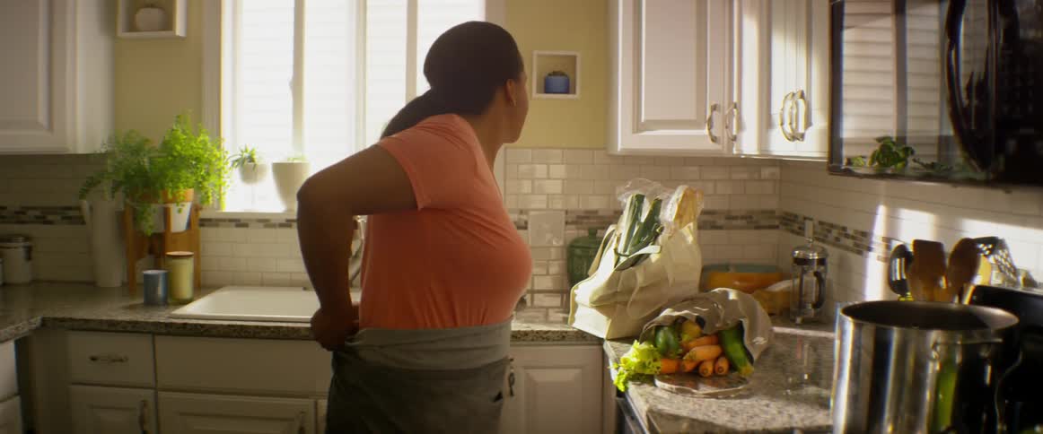 A woman ties an apron around her waist