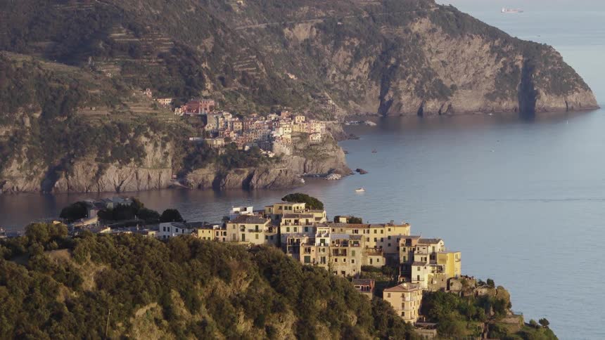 The picturesque coastal villages of Corniglia and Manarola in Cinque Terre, Italy, are bathed in the warm light of golden hour