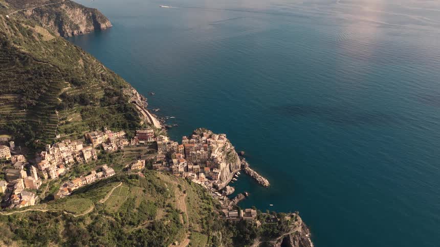 A stunning high aerial view slowly reveals the picturesque village of Manarola, nestled on the cliffs of Cinque Terre, Italy