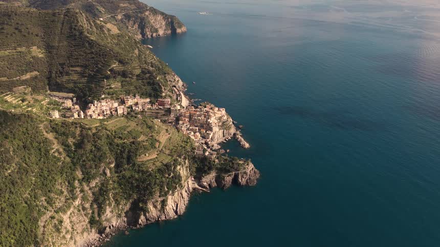 A stunning aerial pullback reveals the iconic village of Manarola nestled on the rugged cliffs of Italy's Cinque Terre coastline