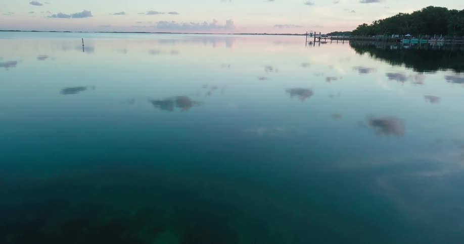 A blue-green mirrored lake stretches out at dusk