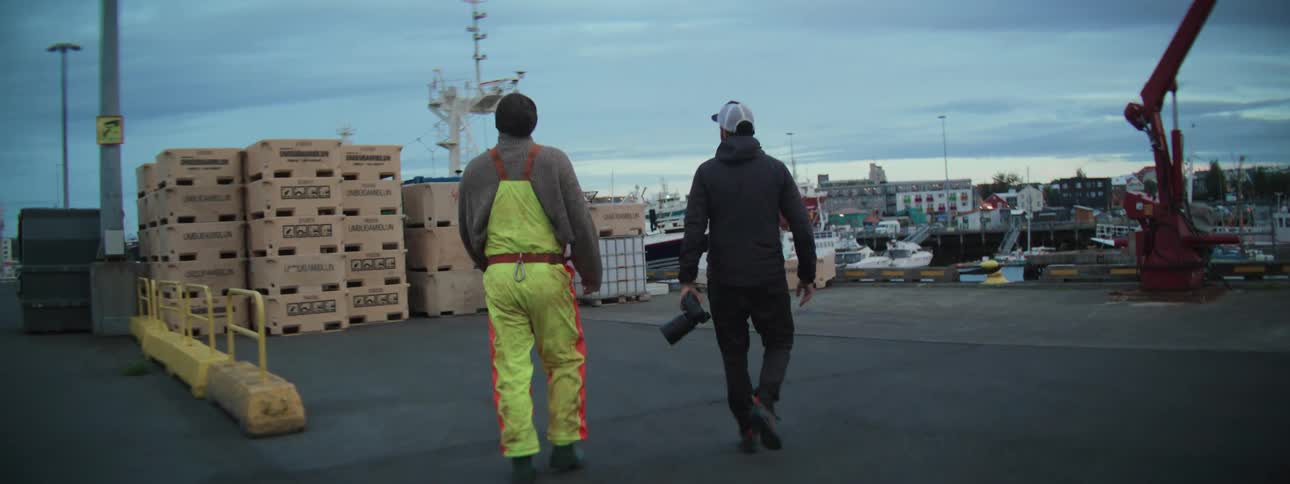A filmmaker walks with a local fisherman through an industrial harbor while documenting his story