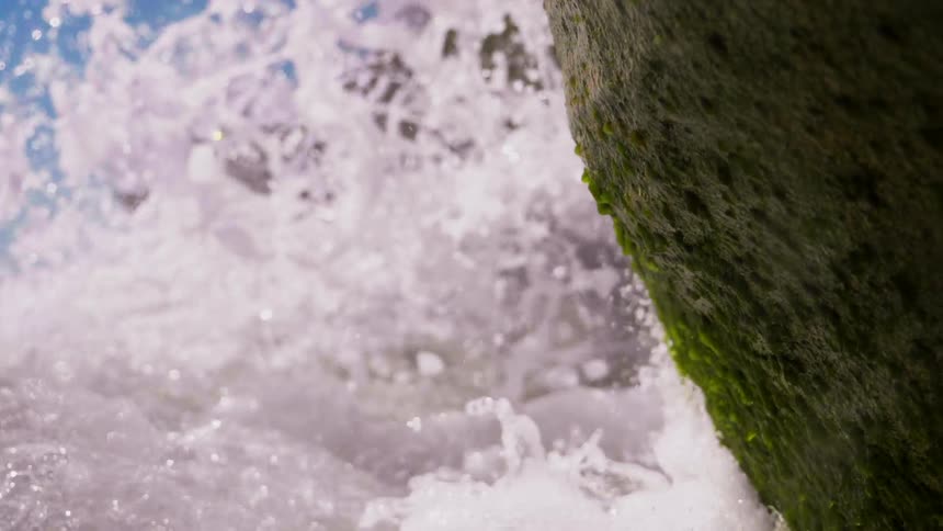 Ocean waves crash into rocks on the beach