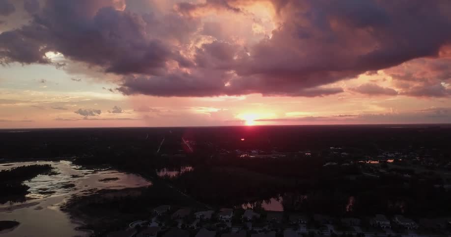 The sun is setting beyond a community on the coast
