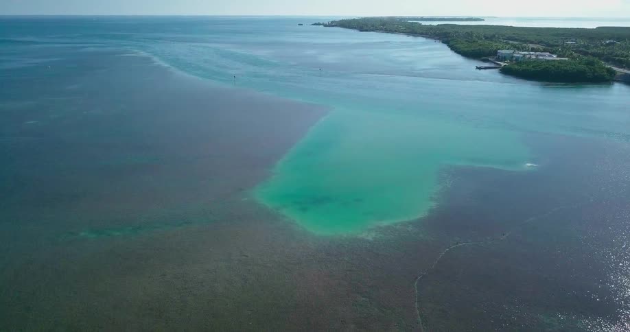 Looking down at a body of water with emerald green and blue, with shades of brown