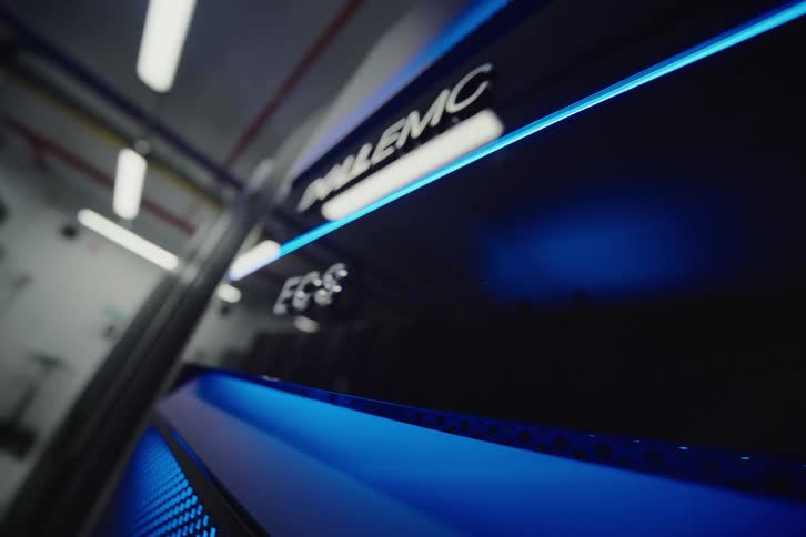 A sleek, low-angle shot of a Dell EMC ECS server rack with glowing blue lights in a high-tech data center