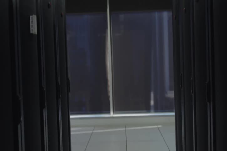 A slow upward tilt shot revealing a modern data center aisle, from the perforated floor to the industrial ceiling