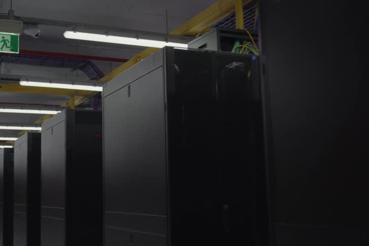 Slow tracking shot past a long row of black server racks with blinking lights in a modern data center