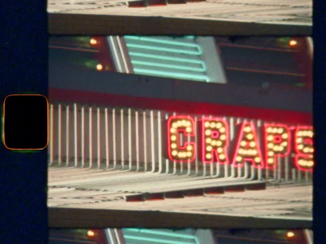 Close-up of a retro 'Craps' Vegas neon sign with flashing bulbs, on Super 8 film