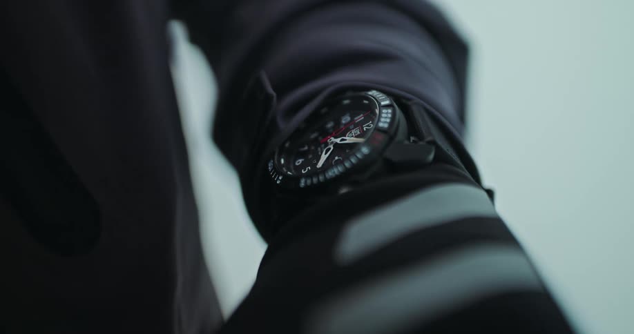 A close-up slow focus reveal of a black analog sports watch on a person's wrist