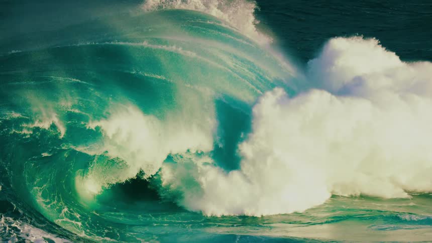 A majestic and powerful turquoise ocean wave builds and crashes in dramatic slow motion, showcasing the raw beauty of nature