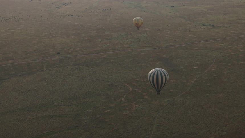 An incredible aerial view of two hot air balloons floating serenely over the expansive African savanna